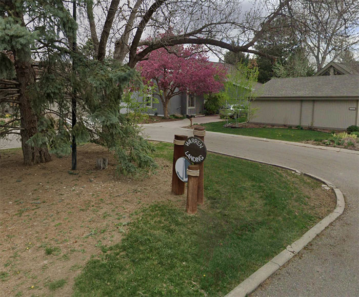 Neighborhood street with tree and Warren Landing sign. Neighborhood street with tree and Warren Landing sign.
