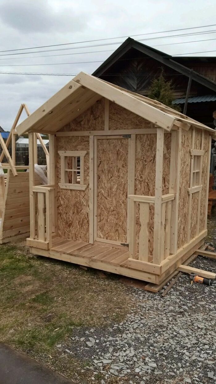 Small wooden shed under construction showcasing detailed woodworking ideas and craftsmanship outdoors.