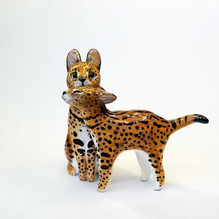 Adorable pocket-sized animal figurine by Vallavica, featuring two spotted creatures embracing.