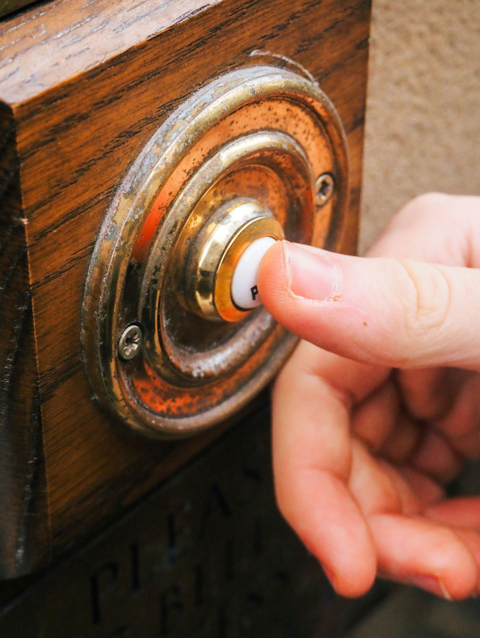 Finger pressing a doorbell, symbolizing people who are very close to their parents.