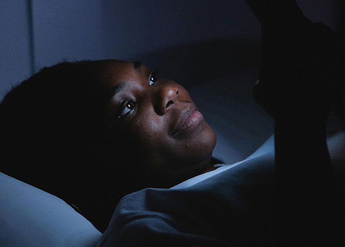 A heartbroken person lying in bed at night, reflecting on how they realized their significant other was cheating.