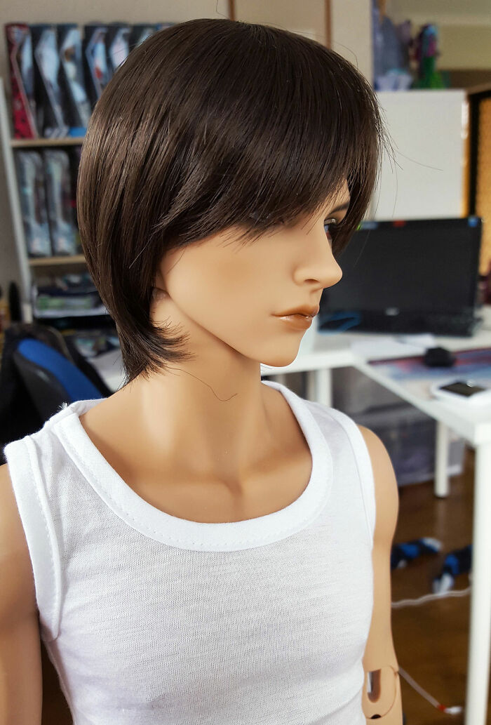 Lifelike mannequin in a white tank top, creating a creepy vibe in a home office setting.