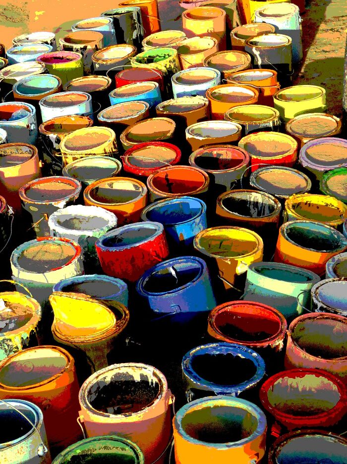 Colorful and creepy display of old paint cans in someone's house.