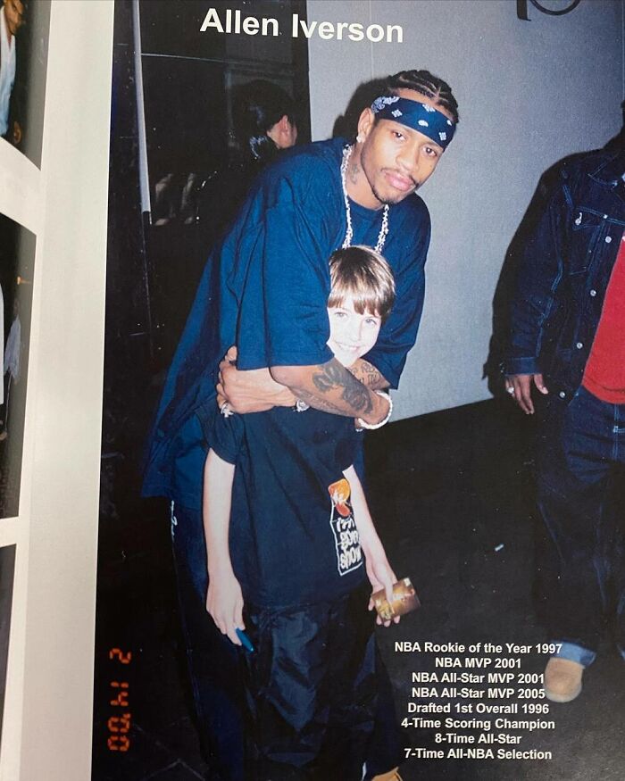 Young boy with celebrity, wearing a blue bandana, embrace in a candid moment at an event.
