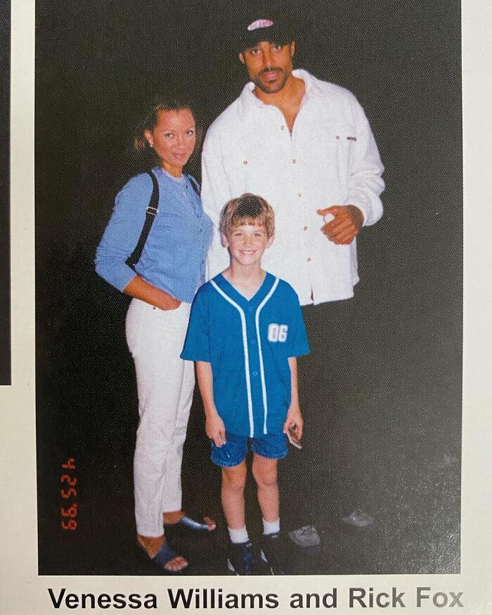 Child posing with celebrities in casual attire.