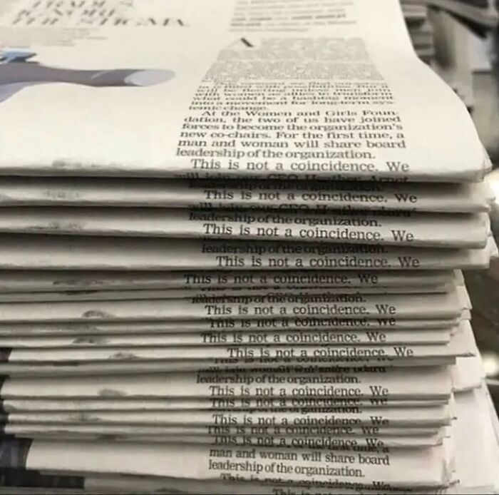 Stack of newspapers with visible repeated text, creating a humorous meme moment.