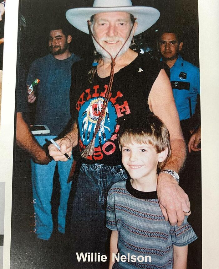 A young boy posing with a celebrity in a casual setting.