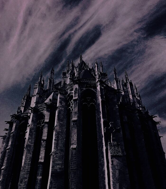 Gothic cathedral under dramatic sky, showcasing dark escapism photography.