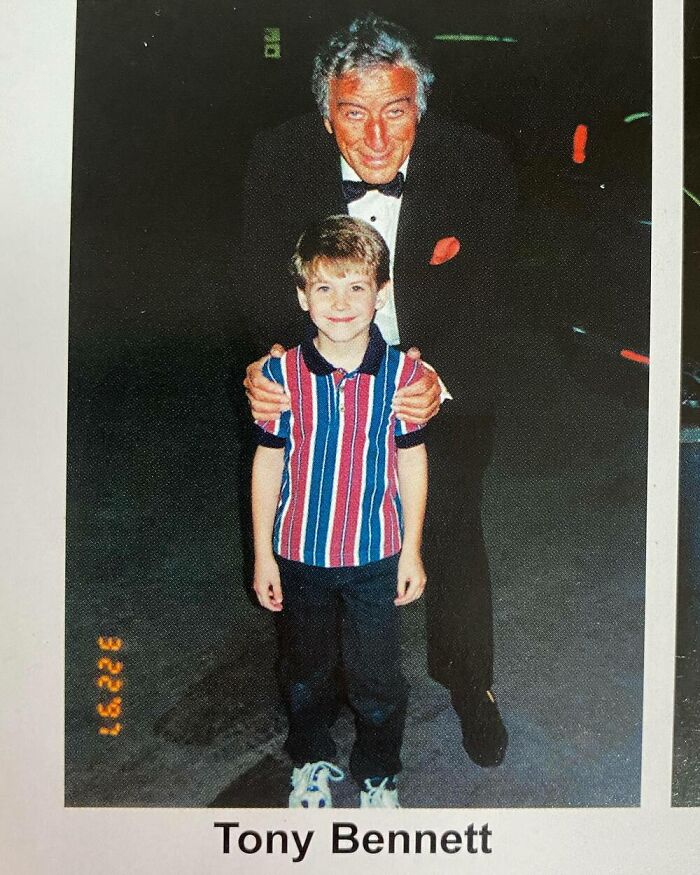Young boy with a celebrity in a tuxedo, smiling together for a photo op.