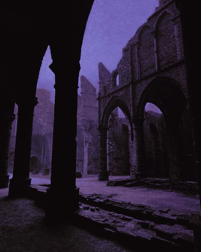 Gothic ruins with arches at night, showcasing dreamy dark escapism photography.