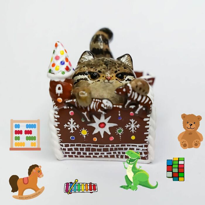 Pocket-sized animal figurine featuring a cat in a decorated gingerbread house with toy illustrations.