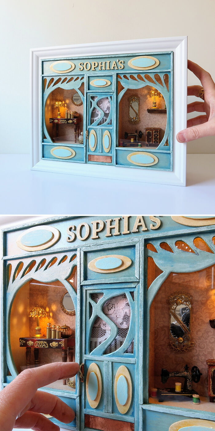 Miniature blue storefront by Tamar Cohen, titled "Sophia's," featuring intricate interior details and a person holding it.
