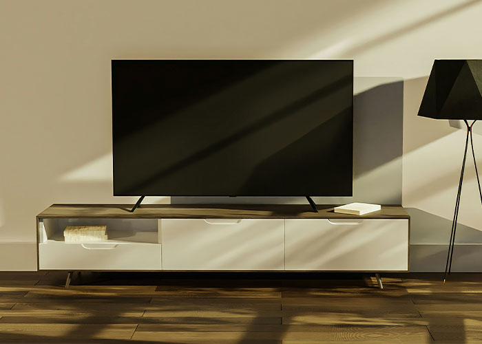 Modern TV setup on a wooden stand with soft sunlight and dark lampshade, reflecting wild rumors ambiance.