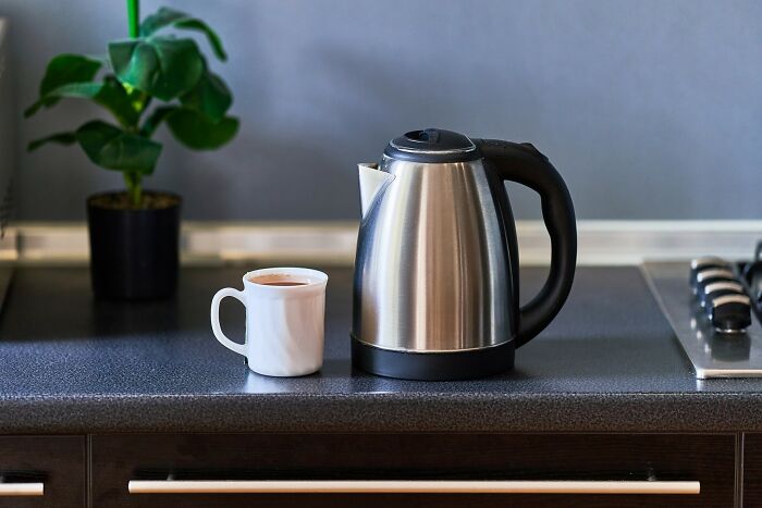 Electric kettle and mug on a kitchen counter, depicting a common item Americans find unusual in non-American contexts.