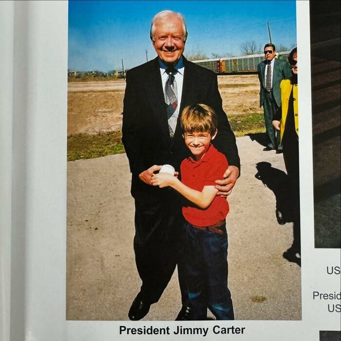 Young boy posing with President, embracing with a smile in an outdoor setting.
