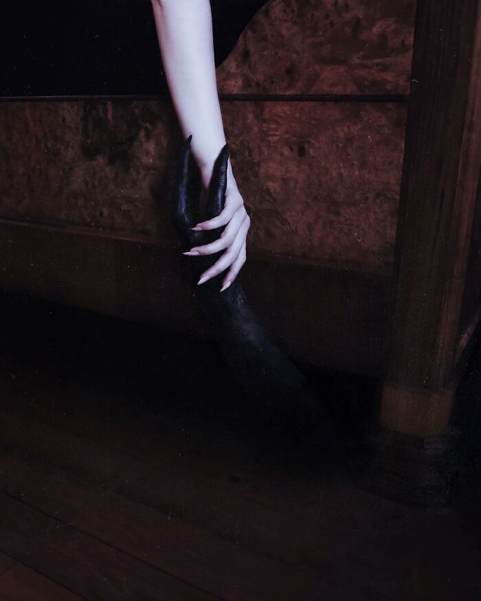 A mysterious hand reaching into darkness beneath a bed, exemplifying dark escapism photography.