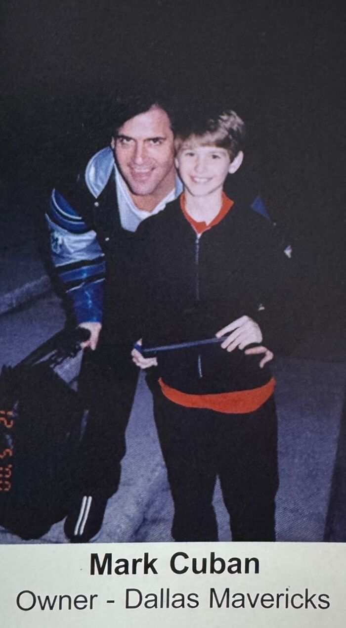 Young boy taking a photo with a celebrity, both smiling outdoors at night.