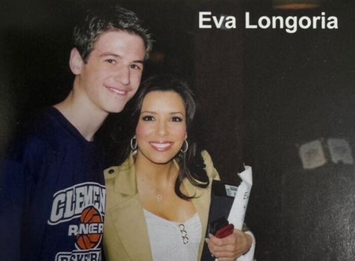 Boy posing for a photo with a celebrity, smiling together.