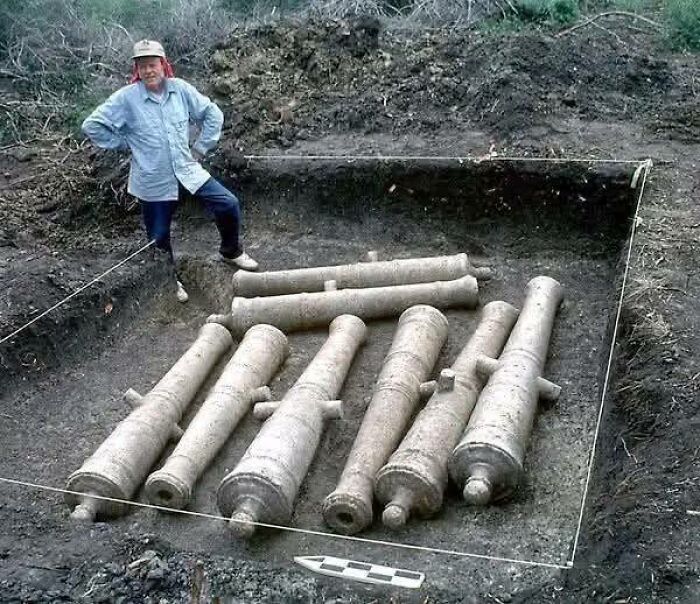 Archaeologist uncovering ancient cannons during excavation featured in archaeology news and architecture group.