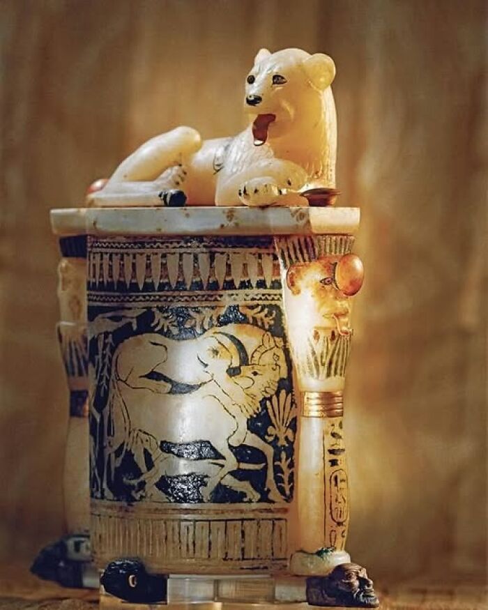 Ancient artifact featuring a carved lion and painted figures, showcasing unique archaeology and architecture craftsmanship.