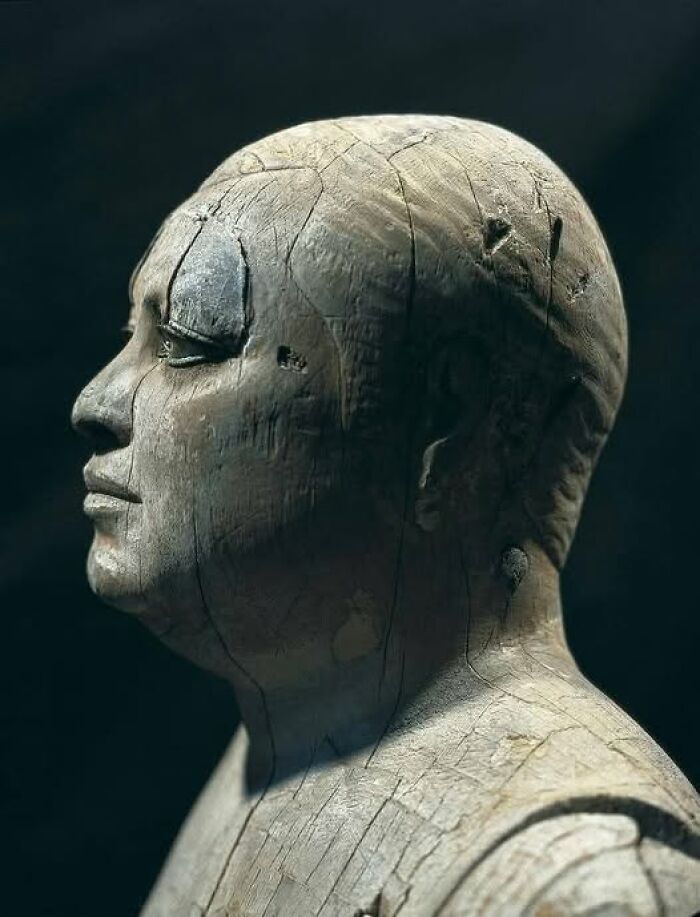 Ancient carved wooden bust showing detailed facial features, highlighting archaeology and architecture discovery.