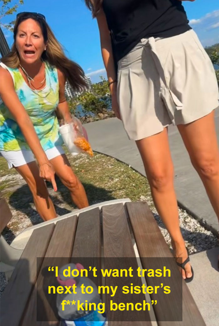 Woman angrily gesturing at a park bench while another stands nearby, both appearing upset during a public confrontation.