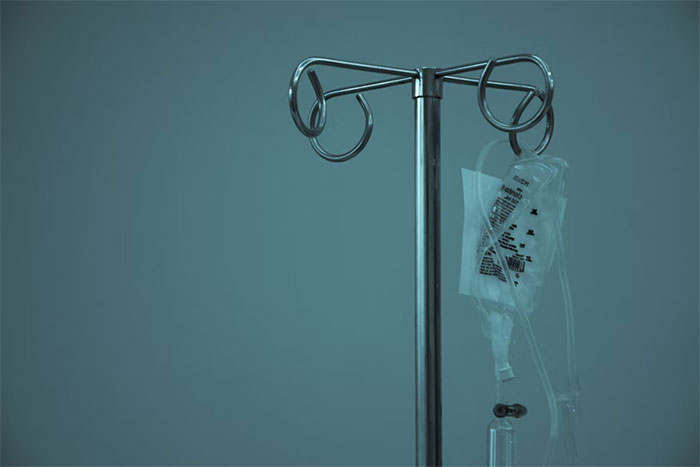 IV stand with a hanging bag in a hospital setting, symbolizing close care relationships.
