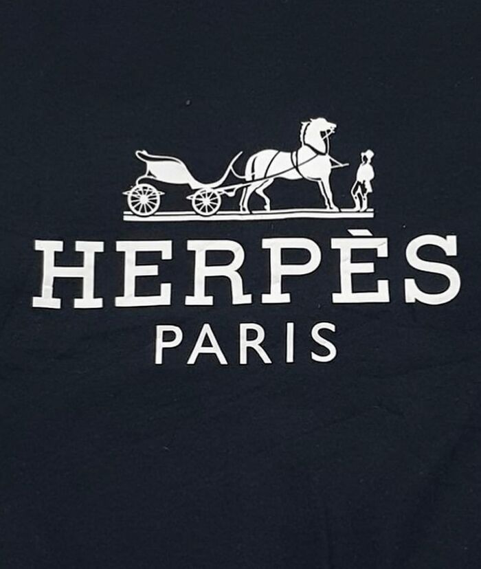 Black T-shirt with funny translation error, saying "HERPÈS PARIS" with carriage graphic.