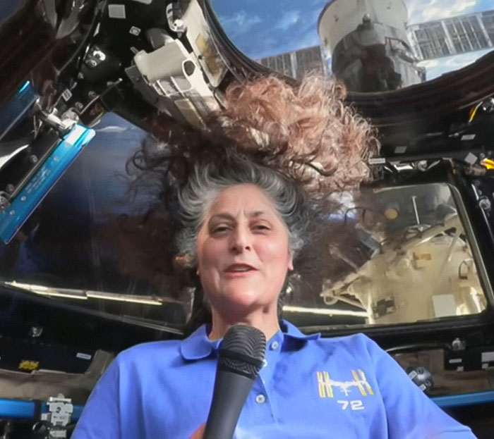 Person in a space capsule, hair floating, sparking Blue Origin conspiracy theories.