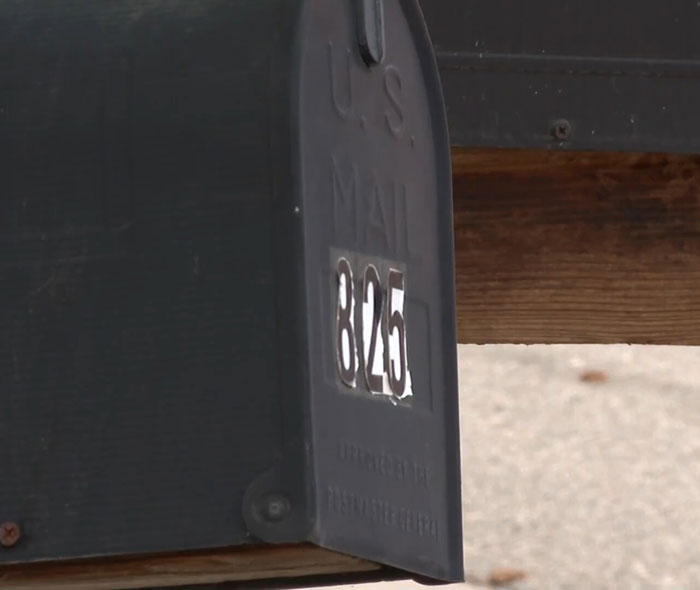 Mailing address number on a black U.S. mailbox with wooden post. Mailing address number on a black U.S. mailbox with wooden post.