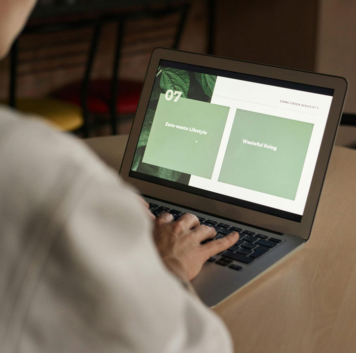 Person using a laptop showing a presentation slide on zero-waste lifestyle and wasteful living with SEO deliverables concept.