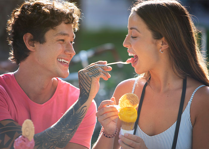 Happy couple sharing ice cream outdoors, illustrating a cheat code in marriage for lasting relationship success.