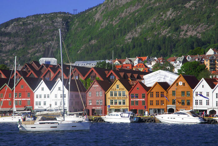 Colorful city waterfront with vibrant buildings and boats, resembling a real-life painting.