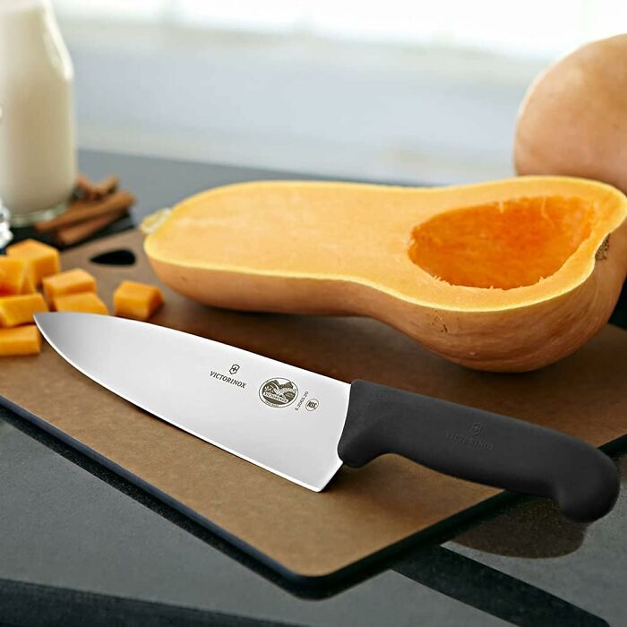 Knife with black handle on cutting board beside sliced butternut squash, showcasing items that last a lifetime.