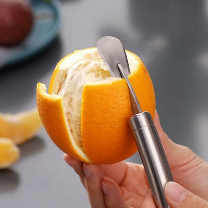 Peeling an orange with a stainless steel kitchen tool from an Amazon haul for affordable kitchen deals.