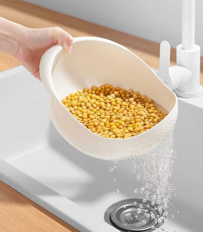 Hand holding a white kitchen colander rinsing yellow lentils over a sink, highlighting Amazon haul kitchen deals.