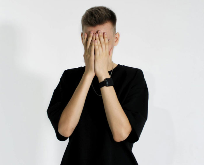 Man with hands on face, stressed over family wanting breakup after girlfriend fights prank.