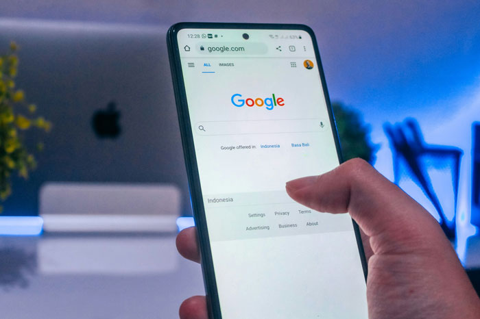 Person holding a smartphone, browsing Google, illustrating internet hacks for easier online life.