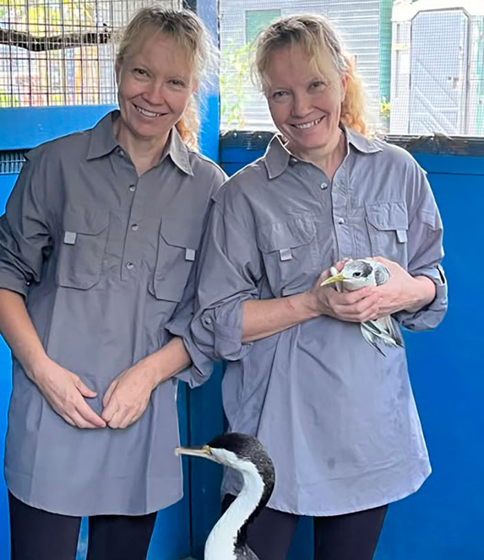 Twins in matching shirts, one holding a bird, amidst backlash after recounting carjacking. Twins in matching shirts, one holding a bird, amidst backlash after recounting carjacking.