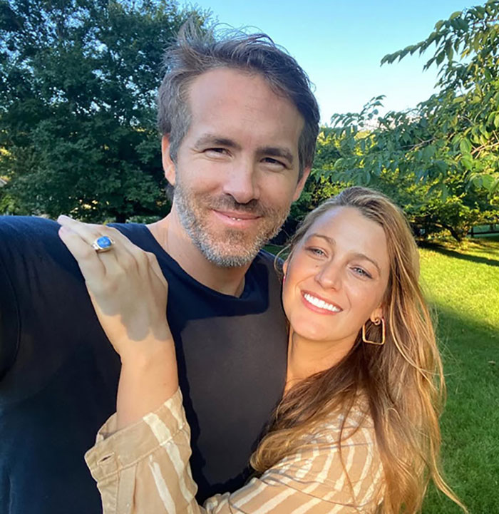 Ryan Reynolds and Blake Lively smiling outdoors, amidst legal concerns.