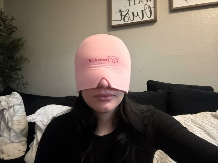 Woman wearing a pink face cover indoors, showcasing one of 22 perfect things to buy.