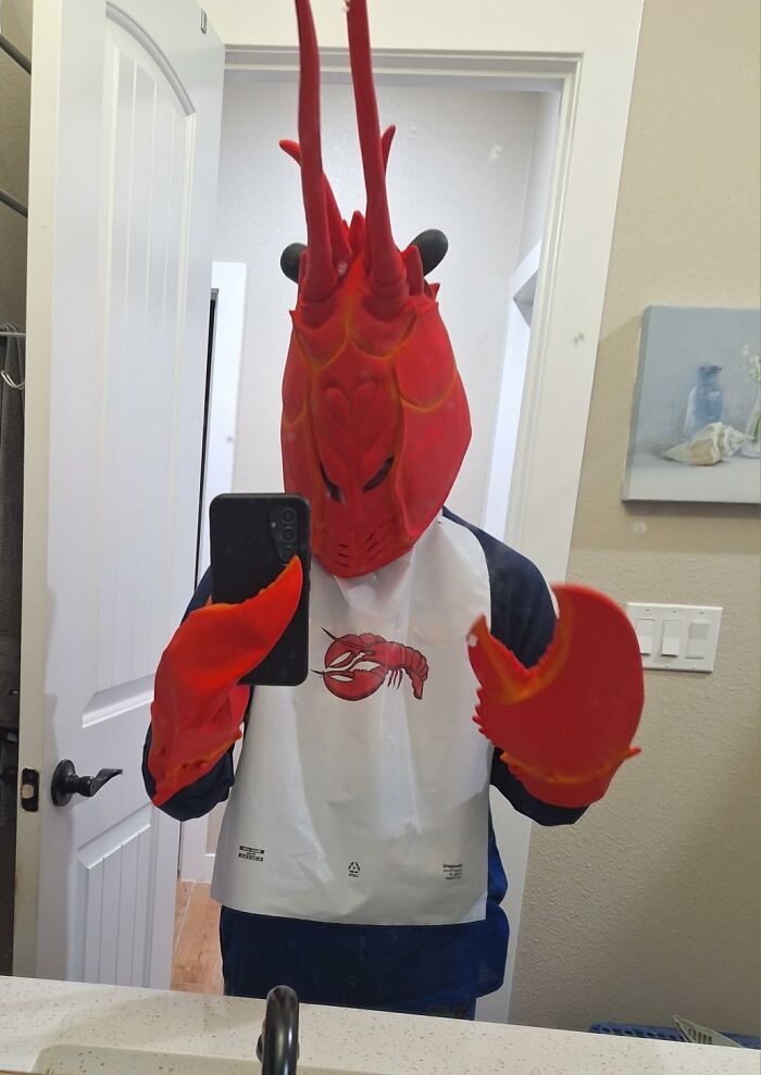 Person in a lobster costume taking a mirror selfie, embodying the quirky friend persona.