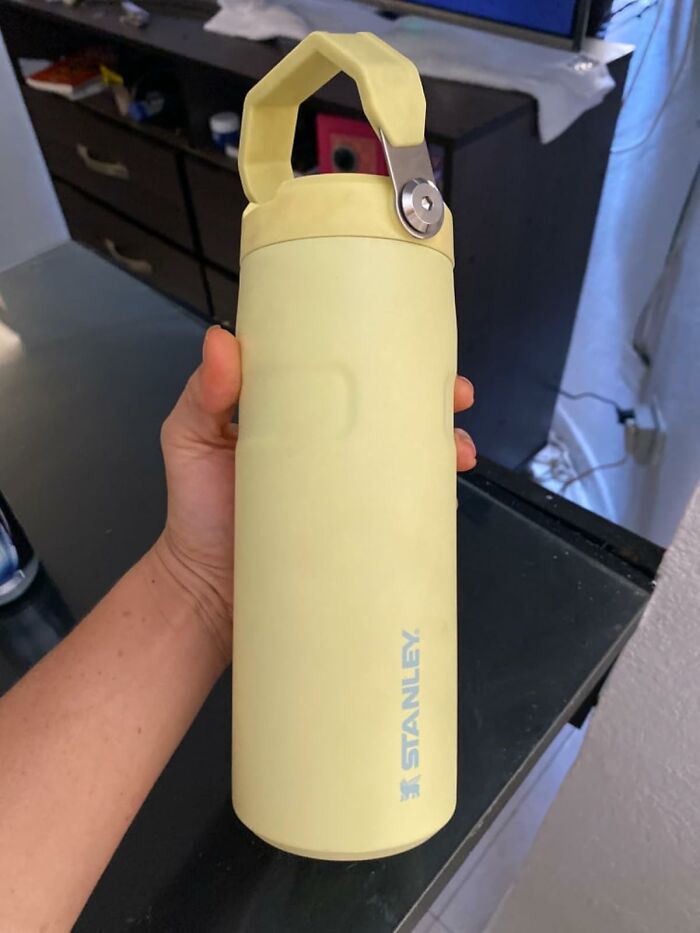 Hand holding a yellow Stanley water bottle, highlighting reasons Wednesday might not totally suck this week.