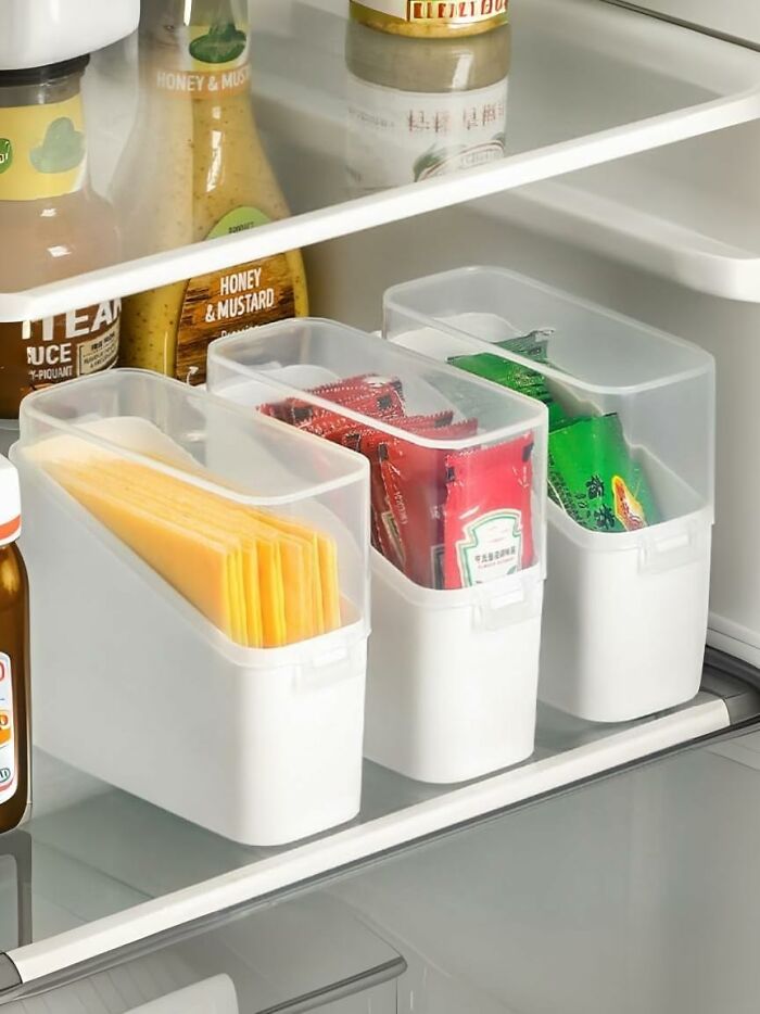White plastic kitchen organizers neatly storing cheese slices and condiment packets in a fridge, ideal Amazon haul kitchen deals.