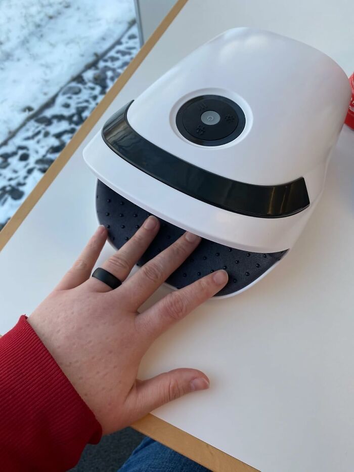 Hand in a modern white hand massager on a wintry day, showcasing a trendsetting treasure.