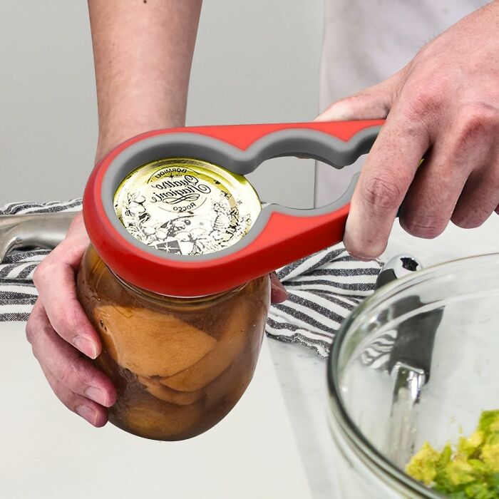 Hands using a red jar opener on a glass jar, highlighting affordable kitchen deals from Amazon haul essentials.
