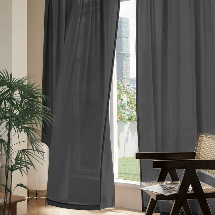 Dark curtains hanging by a window, with cozy chairs, from a low-cost Amazon haul.