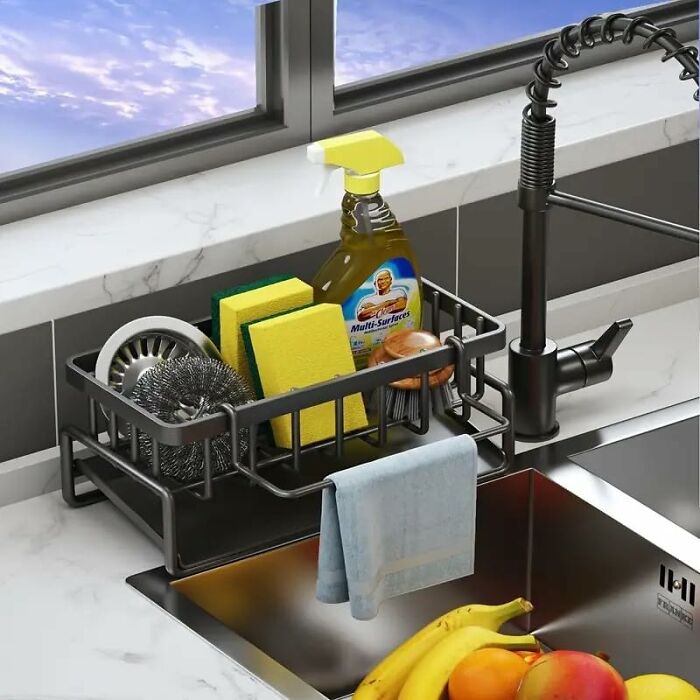 Kitchen cleaning supplies and sponges in a countertop organizer next to a modern faucet and sink, showcasing kitchen deals.