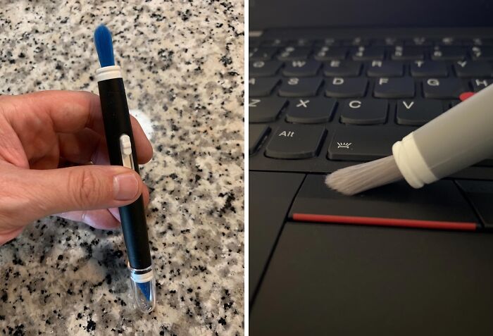 A person holding a dual-ended cleaning brush for keyboards, demonstrating its use on a laptop.