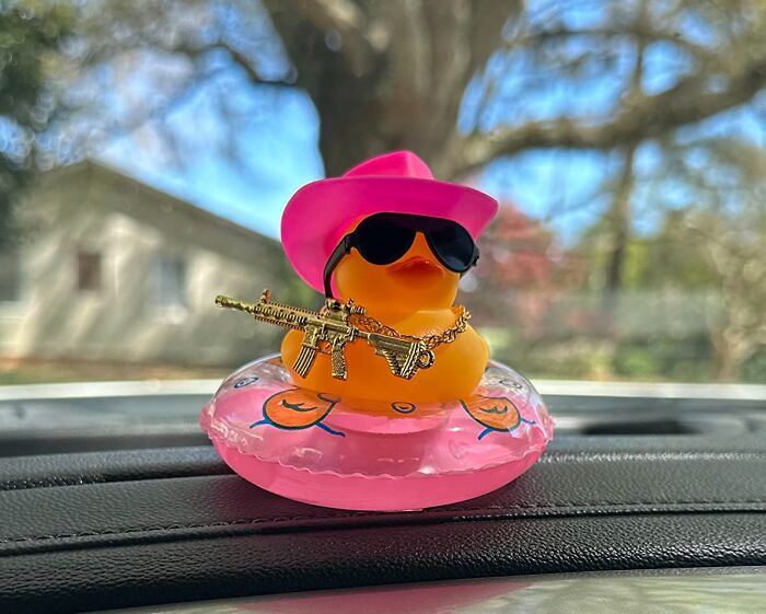 Rubber duck with pink hat and sunglasses holding gold chain gun, one of the quirky Amazon finds blending genius and why does this exist.